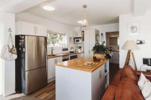 a kitchen and living room with a stainless steel refrigerator at Te Moana Waterfront - beachside accommodation in New Plymouth