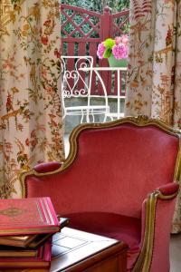 a red couch sitting next to a table with books at Hostellerie de la Motte jean in Saint-Coulomb
