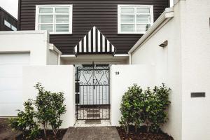 a black and white house with a gate at Buller Noire - luxury New Plymouth oceanview home in New Plymouth