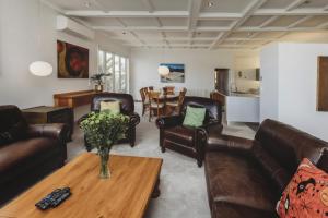 a living room with leather furniture and a table at The Front Office - charming 3BR heritage home in New Plymouth