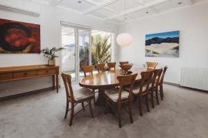 a dining room with a wooden table and chairs at The Front Office - charming 3BR heritage home in New Plymouth
