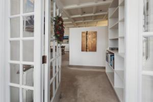 a hallway with white doors and a painting on the wall at The Front Office - charming 3BR heritage home in New Plymouth +13 photos