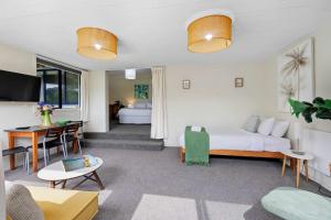 a living room with a bed and a desk in it at Butlers Studio Two in Oakura