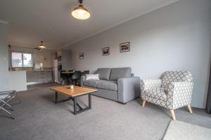 a living room with a couch and chairs and a table at The Window Seat - pet-friendly 1BR apartment in Waitara