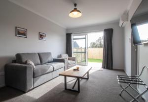 a living room with a couch and a table at The Window Seat - pet-friendly 1BR apartment in Waitara