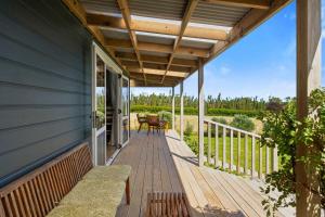 a porch of a house with a wooden deck at Weld Cottage - Sustainable lifestyle property in New Plymouth