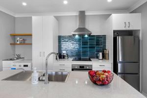a kitchen with a bowl of fruit on a counter at Weld Cottage - Sustainable lifestyle property in New Plymouth