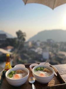 a tray with bowls of soup and a bottle of beer at ผาฮี้แลนด์โฮมสเตย์ in Mae Sai
