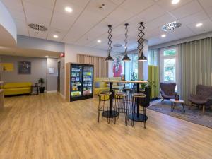 a lobby with a bar and stools in a room at ibis Hotel Frankfurt Messe West in Frankfurt