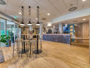 a lobby with a bar and stools in a store at ibis Hotel Frankfurt Messe West in Frankfurt