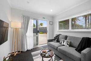 a living room with a couch and a window at Naki Nook - Accommodation Stratford in Stratford