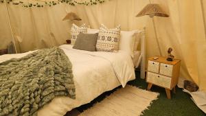 a bedroom with a bed and a nightstand with two lamps at Boutique Teepee Sleeps 2 with Pool in Zújar