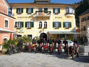 un grupo de personas en bicicleta delante de un edificio en Gasthof Post, en Oberdrauburg