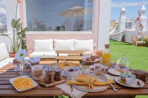 a table with food and drinks on a patio at Casa Rosa Sé - Luxury Boutique Guest House in Faro