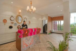 a woman standing behind a counter in a room at Reejas inn's n' suites in Kasauli