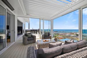 a living room with a couch and chairs and windows at Seaview on Findlay in New Plymouth