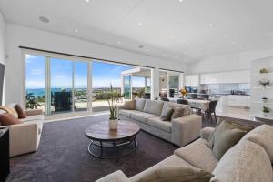 a living room with couches and a table at Seaview on Findlay in New Plymouth