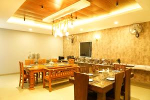 a large dining room with a table and chairs at Winners Hill Resort Walayar by Arcadia in Coimbatore