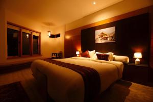 a hotel room with a large bed and a window at Resort Thim -Dorji Paro RiverFront in Paro