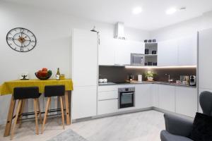 a kitchen with white cabinets and a table and chairs at Glory Suite Zurriola Beach with AC in San Sebastián