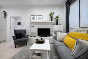 a living room with a couch and a tv at Glory Suite Zurriola Beach with AC in San Sebastián