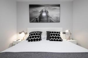 a bedroom with a bed with a picture of a bridge at Glory Suite Zurriola Beach with AC in San Sebastián