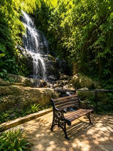 a park bench sitting in front of a waterfall at Akway Resort Beragala Haputale in Beragala