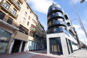 a building on a street next to some buildings at Glory Suite Zurriola Beach with AC in San Sebastián