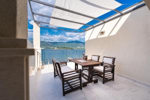 a dining room with a table and chairs on a balcony at Dubravcevic Residence in Tivat
