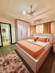 a bedroom with a large bed with an orange blanket at Casa Leo in Agboogba