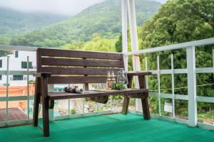 a wooden bench sitting on top of a balcony at Geoje Ocean Love Pension in Geoje +7 photos