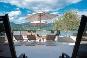 a table and chairs with an umbrella and water at Dubravcevic Residence in Tivat