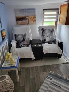 two stuffed teddy bears sitting on chairs in a room at Ferienhaus Deubetal Nr.10 in Stadtilm