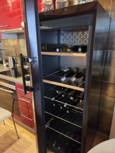 a refrigerator filled with wine bottles in a kitchen at Apartmán Kräm in Klatovy +8 photos