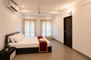 a bedroom with a bed and a large window at Zenora Suites in Kozhikode