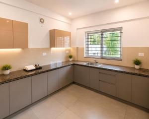 a large kitchen with a sink and a window at Zenora Suites in Kozhikode