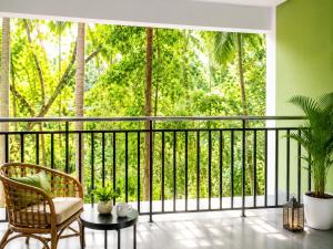 a balcony with a view of the forest at Zenora Suites in Kozhikode
