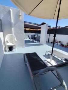 a patio with an umbrella and a table and chairs at Paraiso La Mata in La Mata