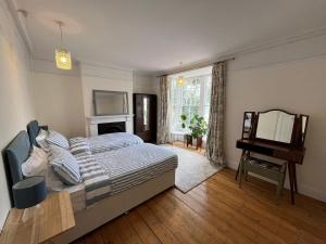 a bedroom with a bed and a mirror and a piano at Number 29 in Melcombe Regis