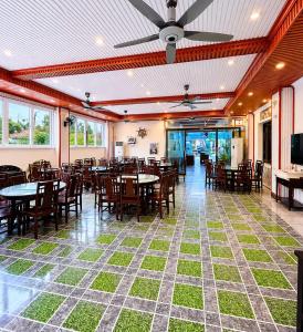 a dining room with tables and chairs and windows at Paloma Hotel Quan Lan in Quan Lạn