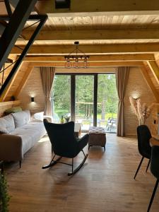 an attic living room with a couch and chairs at Villa Tara in Žabljak