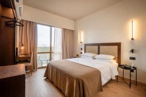 a hotel room with a bed and a large window at Olympic Hotel in Heraklio +127 photos