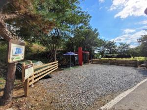 a park with a wooden fence and a red structure at Gapyeong Petmily Dog Pension in Gapyeong