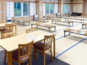 an empty classroom with tables and chairs at まだらおの湯 in Nakano