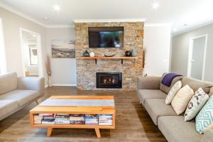 a living room with two couches and a fireplace at Amaroo in Bright