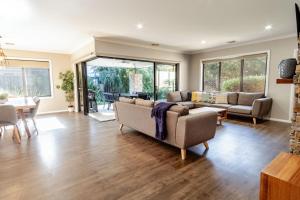 a living room with a couch and a dining room at Amaroo in Bright