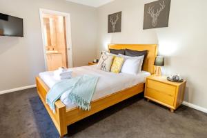 a bedroom with a large bed with white sheets and pillows at Amaroo in Bright