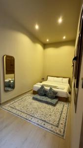 a bedroom with a bed and a mirror and a rug at Room 7 in Nizwa