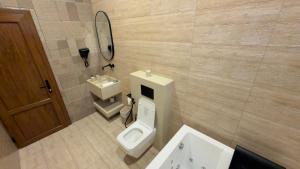 a bathroom with a toilet and a sink and a mirror at Room 7 in Nizwa