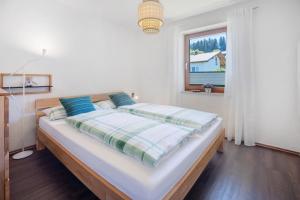 a large bed in a bedroom with a window at Ferienwohnung Krokus in Weiler-Simmerberg